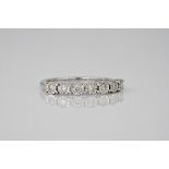 A 9ct white gold and diamond 7 stone ring, the diamonds totalling approximately 0.21ct and held in