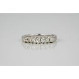 An 18ct white gold and diamond ring, the polished white gold band featuring 7 round brilliant cut