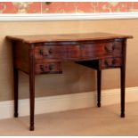 A George III serpentine mahogany three drawer dressing table, the moulded top over a full width