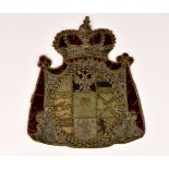 An 18th century stumpwork, silk embroidered and velvet armorial panel, the circular armorial with