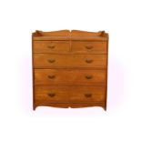 A late Victorian solid ash chest of drawers, the shaped three quarter gallery top over two short and
