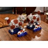 A pair of modern Chinese porcelain cats in the style of Staffordshire, raised on rectangular blue