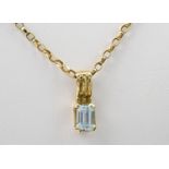 A 9ct gold and pale blue topaz pendant, the emerald cut topaz on a reeded bale, on a 9ct gold