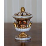 An early 19th century Derby urn form ink stand, with Imari style decoration, foliate cover with cone
