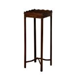 A George III mahogany tea kettle stand, the square tray top with wavy rim, over a candle slide and