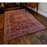 A Sarouk rug, late 20th century, with all over floral and vine decoration on a madder ground, with