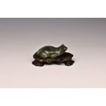 A Chinese carved labradorite figure of a frog on hardwood stand, the frog with black glass bead