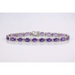 An 18ct white gold, amethyst and diamond bracelet, the oval cut amethysts weighing approximately 9.
