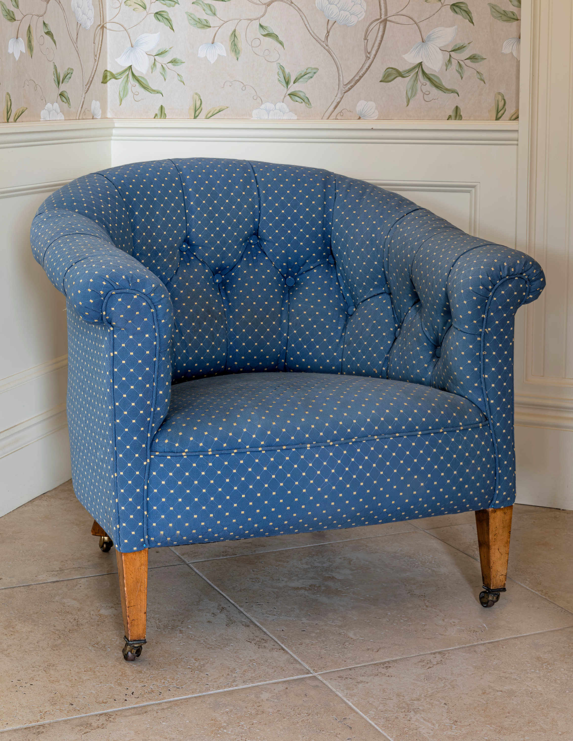 A 19th century tub back armchair, the buttoned back, scrolled arms and seat in blue and gold