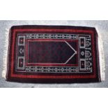 A Persian prayer rug, worked in black, ivory, claret and bright red, 54 x 33¾in. (137 x 85.75cm.).