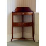 An early 19th century mahogany corner wash stand, the shaped back over a later fixed shelf, above