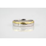 An 18ct white and yellow gold ring set with a single emerald cut diamond, the white gold band tipped