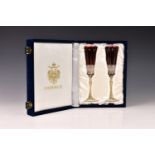 A boxed set of two Fabergé Xenia cut crystal ruby champagne flutes, late 20th century, the base