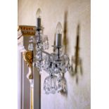 A set of five twin branch cut glass wall lights, second half 20th century, each with two scrolled