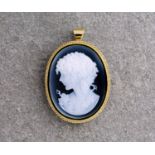 An 18ct yellow gold and inky blue glass cameo pendant / brooch, featuring the bust of a female
