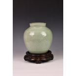 A Chinese celadon porcelain vase on hardwood base, 19th century or later, of ovoid form, decorated