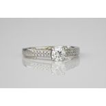 A platinum and diamond ring, the central round brilliant cut diamond weighing approximately 0.40ct
