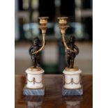 A pair of French late 19th century bronze, ormolu and marble candlesticks, in the form of cherubs