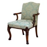 A George II style carved and stained beech wood armchair, circa 1900, the serpentine upholstered