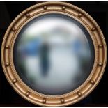 A Regency style convex mirror, 1920s, with ball and crossed ribbon decorated frame, 21in. (53.25cm.)