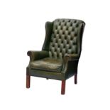 A George III style green buttoned leather wingback armchair, second half 20th century, raised on