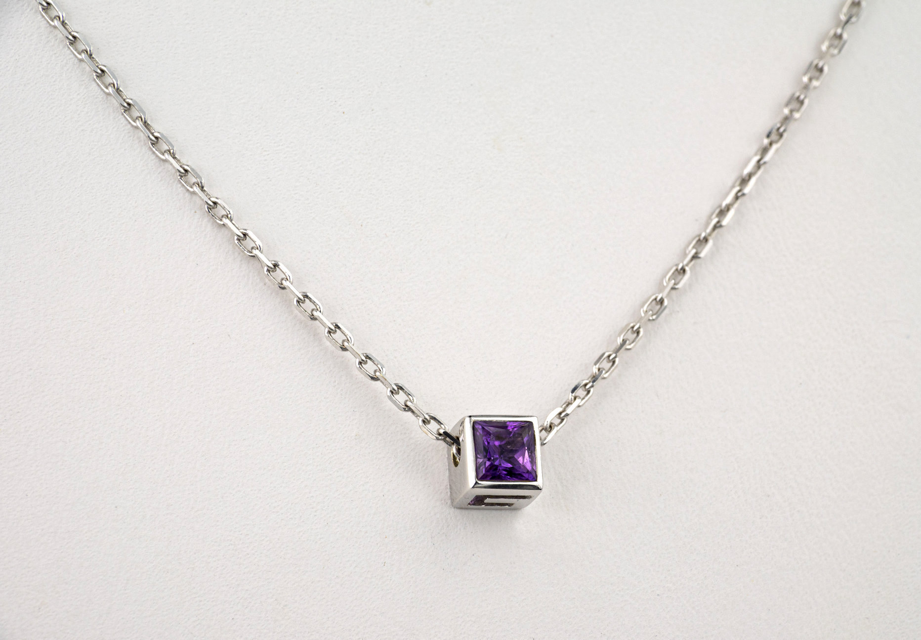 A Gucci 18ct white gold and amethyst pendant and matching stud earrings, the square cut amethysts
