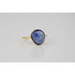 An 18ct yellow gold and sapphire ring, the central fancy cut sapphire held in a rubover setting on a