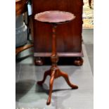 A George II style mahogany wine table, the dished, shaped circular top on a turned and gadroon