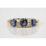 An antique 18ct yellow gold, sapphire and diamond 7 stone ring, featuring 3 graduating cushion cut