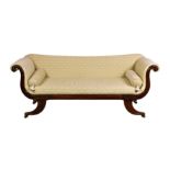 A Regency mahogany framed settee, with slightly concave back over upswept S-shaped ends and leaf