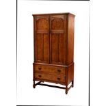 A small oak and burr walnut linen press, 1920s, the moulded top over a pair of three panel doors,