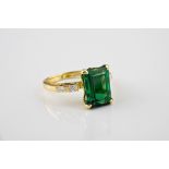 An 18ct yellow gold, green tourmaline and diamond ring, the emerald cut green tourmaline over