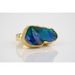 A striking handmade 18ct yellow gold and black opal ring, the large, abstractly shaped opal