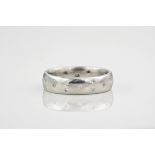 An 18ct white gold and diamond ring, the diamonds flushed into the polished band in a scatter