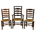 A matched set of three 18th century ladderback chairs, comprising a beech and elm armchair with