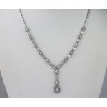 An 18ct white gold and diamond necklace, featuring emerald, baguette, pear and brilliant cut