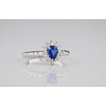 An 18ct white gold, diamond and sapphire cluster ring, the pear cut sapphire cornflower blue in