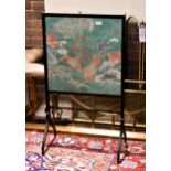 A Regency style ebonised fire screen, the screen lined with Liberty fabric depicting Oriental