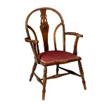 A 1930s oak hoop back open armchair, with pierced shaped splat and curved bar back, over a