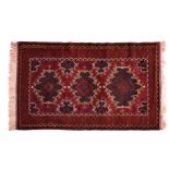 A Kazak rug, third quarter 20th century, the claret red field with three dark blue lozenge