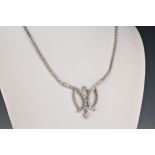 A 14ct white gold and diamond necklet, the bright cut and beaded necklace with a central tied ribbon