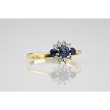 A 9ct yellow gold, diamond and sapphire cluster ring, the central round cut sapphire measuring