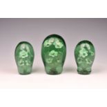 A graduated set of three Victorian glass dump weight with sulphide floral inclusion, each with a