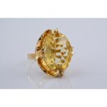 A large 9ct yellow gold and citrine cocktail ring, the central citrine a golden yellow, in an oval