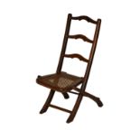 A Victorian walnut cane seated folding child's chair, with three rail back, 23¼in. (59cm.) high, 9½