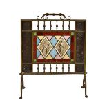 A Victorian brass and stained glass fire screen, the pierced rectangular screen decorated with