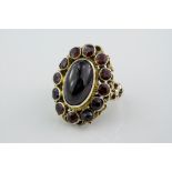 A silver and cabochon garnet ring, the central cabochon garnet measuring approximately 22x11mm and