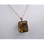 A 1970s 20ct smoky quartz pendant, the smoky quartz is emerald cut, light golden brown in colour and
