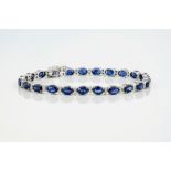 An 18ct white gold, sapphire and diamond bracelet, featuring approximately 13.50ct of oval cut