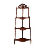 A Victorian walnut veneered four tier corner whatnot, the graduated serpentine-fronted shelves